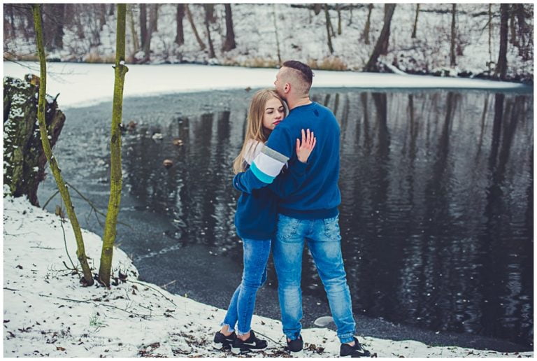 Para obejmuje się zimą nad leśnym jeziorem — zdjęcie z portfolio Andrzeja Paradowskiego