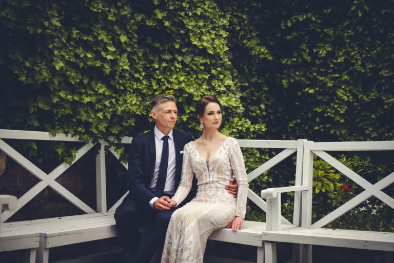 Para młoda na białej ławce – romantyczna fotografia ślubna
