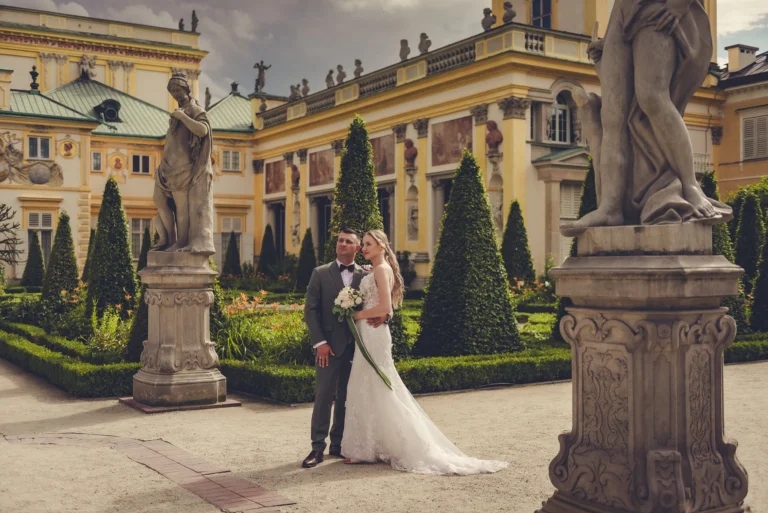 Para młoda przed pałacem w ogrodzie z rzeźbami