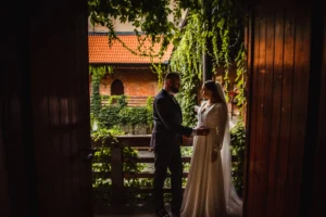 Deszcz w dniu ślubu i podczas sesji — jak przygotować plan B? Para młoda na drewnianym tarasie wśród zieleni